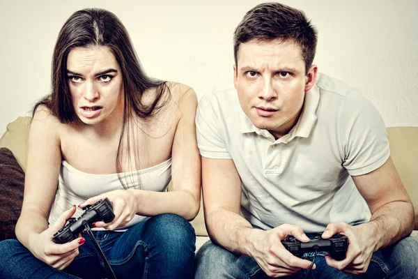 couple sitting in living room and play video games on console o