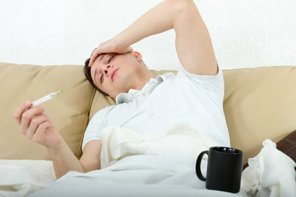 Portrait of man with headache lying sick in bed