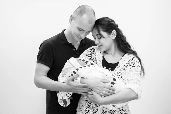 Happy family holding their newborn baby in her arms.Black and white photography