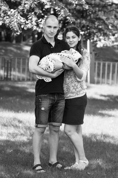 Happy couple holding their newborn daughter in her arms. Outdoors.Black and white photography.Black and white photography
