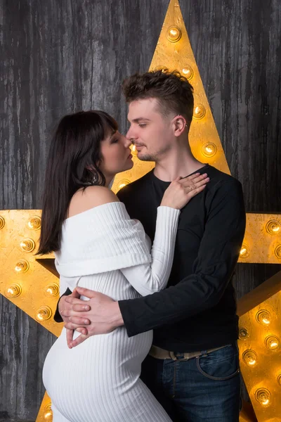 Beautiful couple in front of a glowing star. Pregnancy.