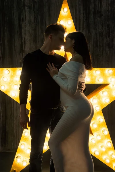 Beautiful couple in front of a glowing star. Pregnancy.