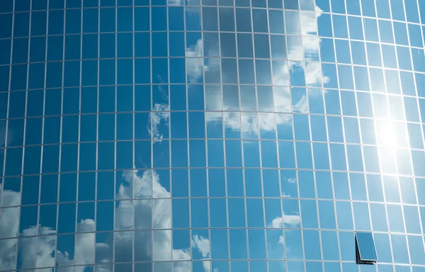 Blue sky reflected at building windows