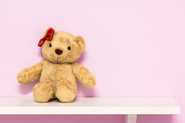 Classic teddy bear on shelf.