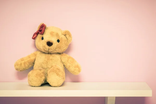 Classic teddy bear on shelf.