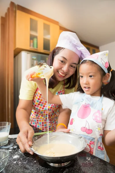 Asian mother and daughter enjoy making pancake