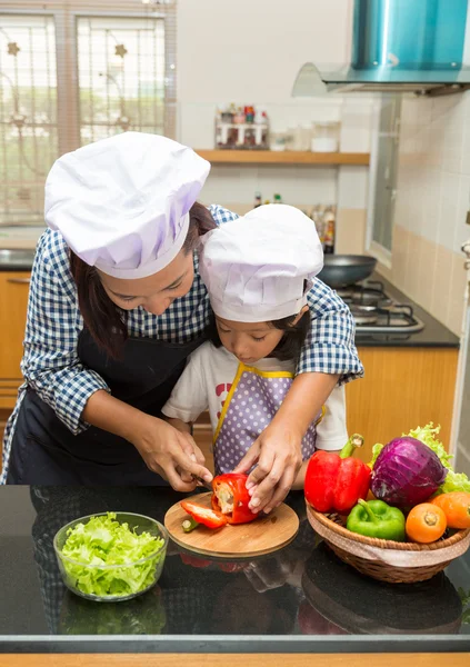 Asian mother teaching daughter making salad in kitchen,Cooking  concept of happy asian little girl and mother making salad