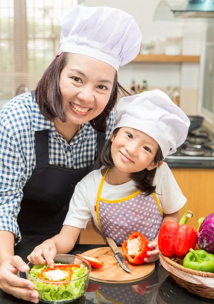 Asian mother teaching daughter making salad in kitchen,Cooking  concept of happy asian little girl and mother making salad