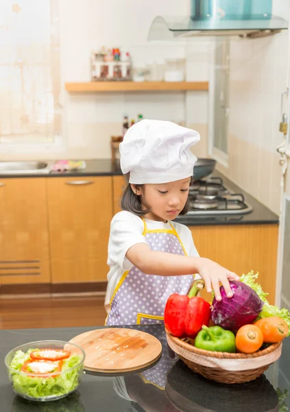 Little asian girl preparing vegetable to making salad