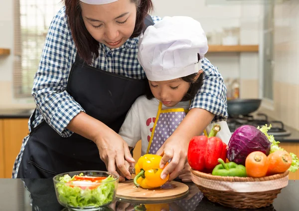 Asian mother teaching daughter making salad in kitchen,Cooking  concept of happy asian little girl and mother making salad