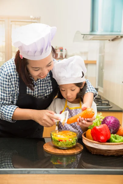 Asian mother teaching daughter making salad in kitchen,Cooking  Cooking  concept of happy asian little girl and mother making salad