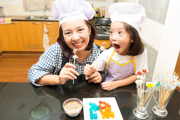 Mother and daughter making jelly candy in ktichen