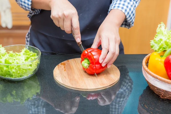 Female cook cutting bell pepper