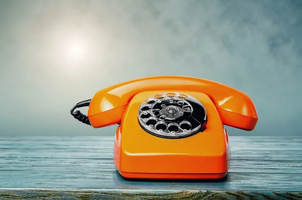 Orange phone on wooden table