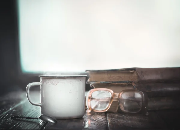 Old mug with hot coffee books, glasses