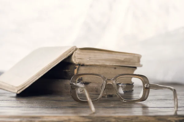 Eyeglasses and books on table