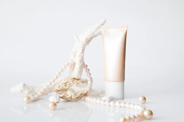 Nameless cosmetic tube and pearl in shell decorated with pearl n