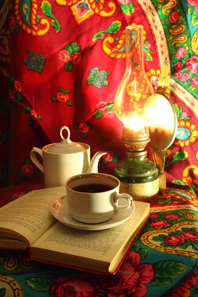 Cup of hot tea in the winter evening and book