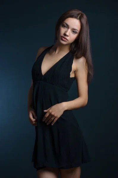 Beautiful girl in the dress topic: Charming brunette in a black dress in the studio on a dark background