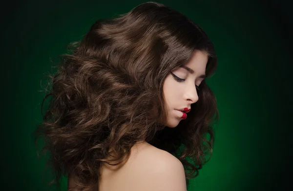 Hair and make-up topic: a very beautiful girl model with lush hair and creative make-up on green background