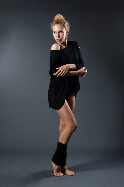 Modern classical dance theme: beautiful girl dancing sensual dance in a studio on a gray background