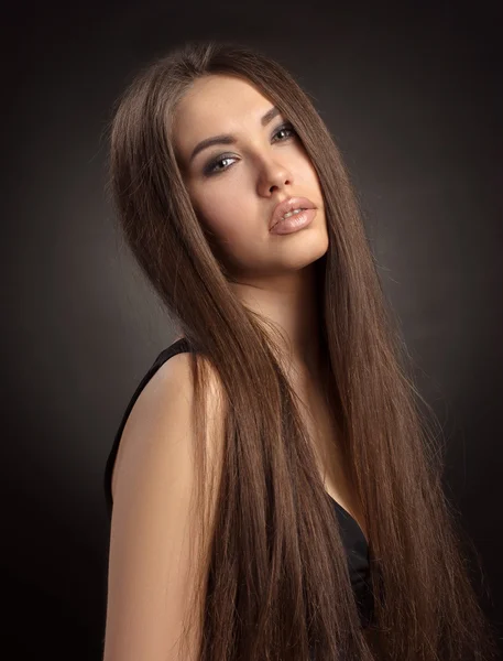 Dramatic portrait of a girl theme: portrait of a young beautiful girl on a dark background in the studio