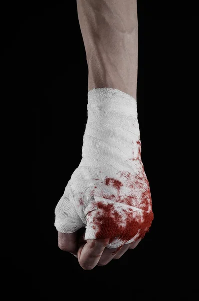 Shook his bloody hand in a bandage, bloody bandage, fight club, street fight, violence, bloody theme, isolated, bloody fists, boxer, tied his hands with a bandage, black background