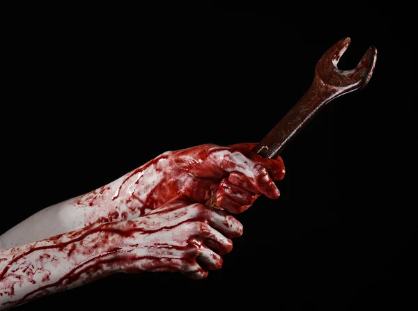 Bloody hand holding a big wrench, bloody wrench, big key, bloody theme, halloween theme, crazy mechanic, murderer, psycho, violence, zombies, black background, isolated, revolution