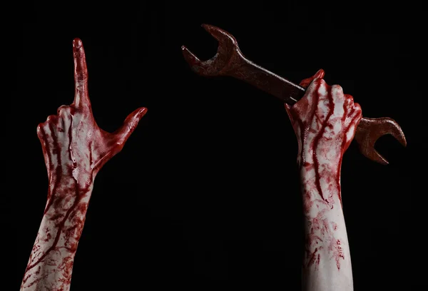 Bloody hand holding a big wrench, bloody wrench, big key, bloody theme, halloween theme, crazy mechanic, murderer, psycho, violence, zombies, black background, isolated, revolution