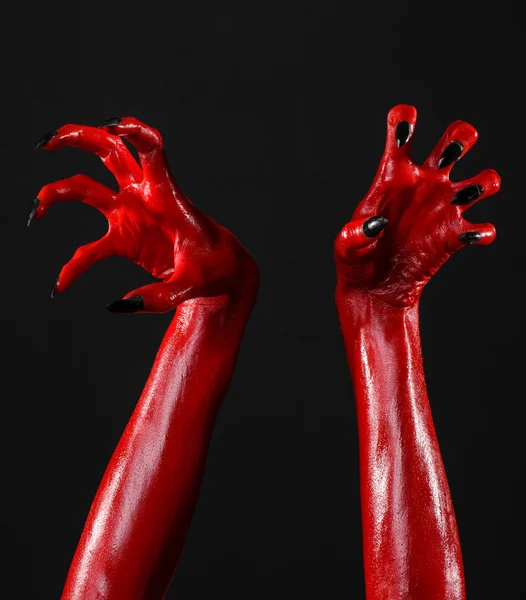 Red Devil's hands, red hands of Satan, Halloween theme, black background, isolated