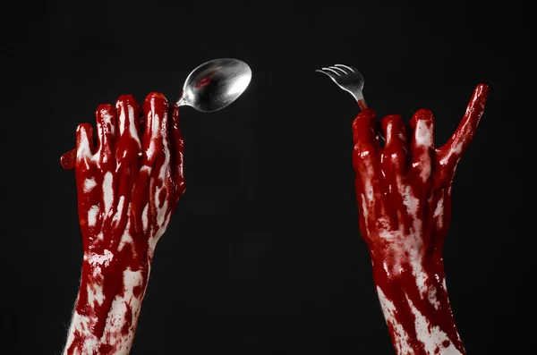 Bloody hand holding a spoon, fork, halloween theme, bloody spoon, fork, black background, isolated