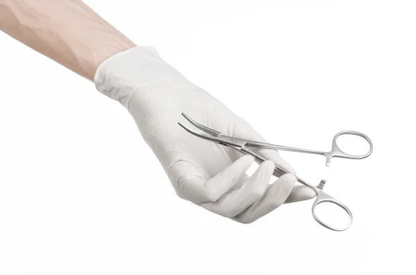 Surgery and Medical theme: doctor\'s hand in a white glove holding a surgical clip isolated on white background