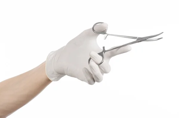 Surgery and Medical theme: doctor's hand in a white glove holding a surgical clip isolated on white background