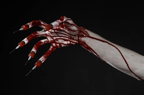 Bloody hand with syringe on the fingers, toes syringes, hand syringes, horrible bloody hand, halloween theme, zombie doctor, black background, isolated