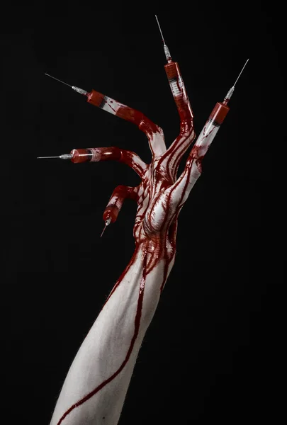 Bloody hand with syringe on the fingers, toes syringes, hand syringes, horrible bloody hand, halloween theme, zombie doctor, black background, isolated