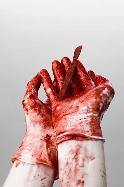 Bloody hands in gloves with the scalpel, white background, isolated, doctor, killer, maniac