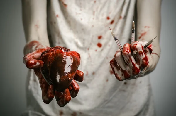 Social advertising and the fight against drug addiction: bloody hands addict holding syringe and bloody human heart