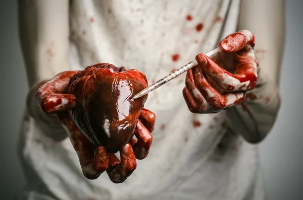 Social advertising and the fight against drug addiction: bloody hands addict holding syringe and bloody human heart