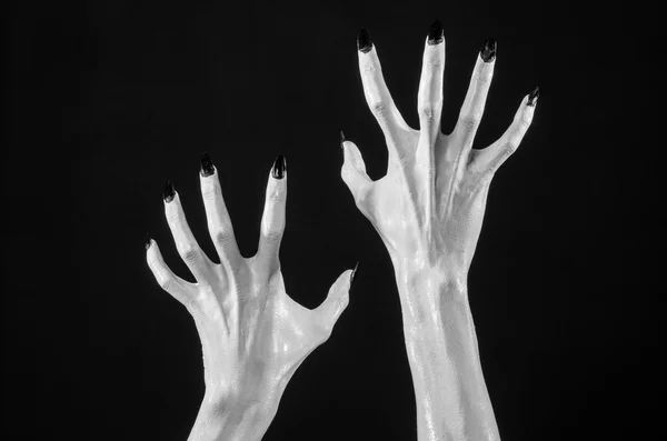 White hands of death with black nails, white death, the devil's hands, the hands of a demon, white skin, halloween theme, black background, isolated