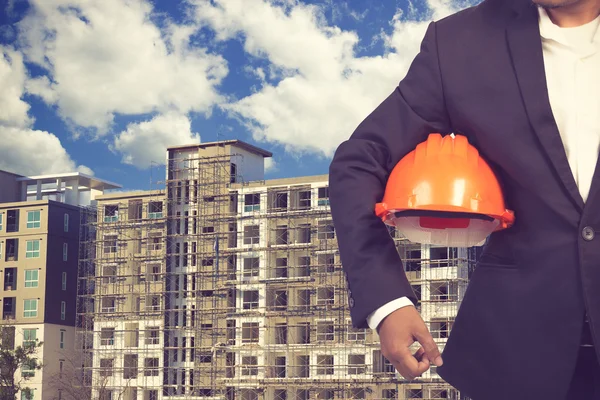 Engineer holding helmet for working at footing of building const