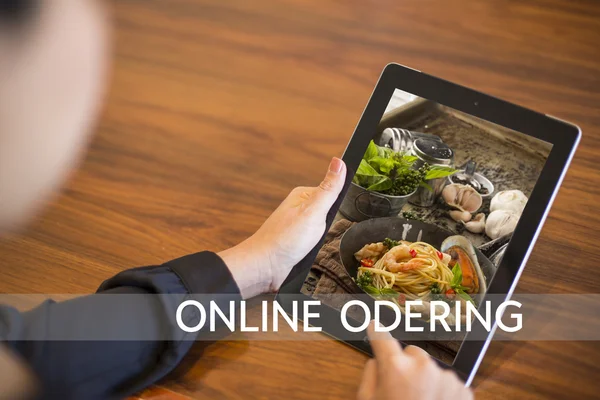 Hand holding tablet with Order food online with office backgroun
