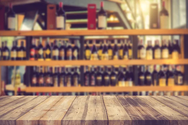 Wood table and wine Liquor bottle on shelf Blurred background ca