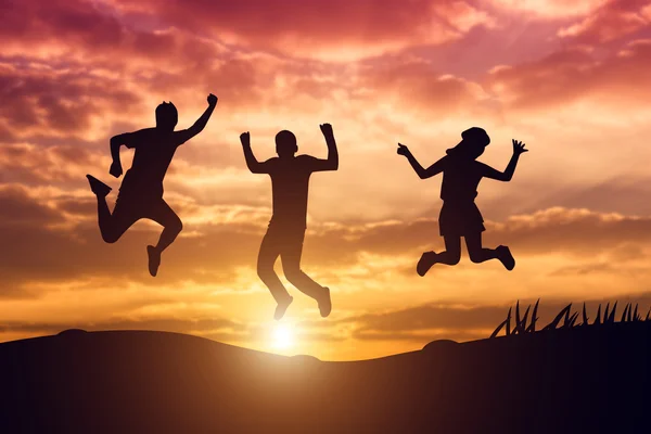 Silhouette of Group of Hipster Teenagers Jumping at the Sunset
