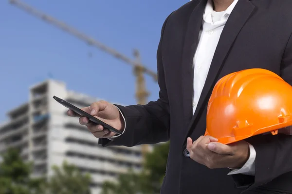 Engineer checking emails on the phone on construction background
