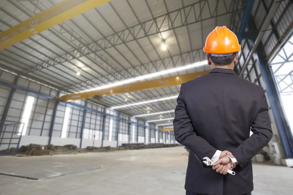 Engineer holding orange helmet for workers security on factory b