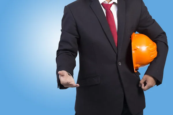 Engineer holding orange helmet for workers security on blue back