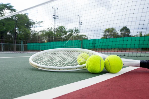 Close up view of tennis racket and balls on the tennis court
