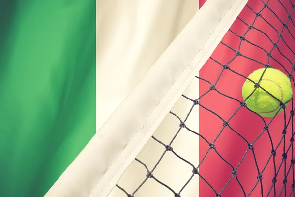 Tennis ball in net on ITALY flag background.vintage color