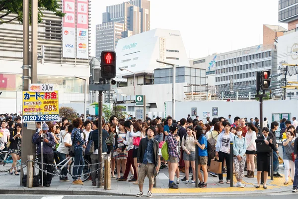 Tokyo ,Japan - May 25 ,2014. Many people cross the street and tr