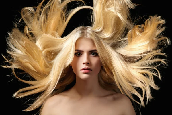 Portrait of beautiful young blonde girl with flying hair
